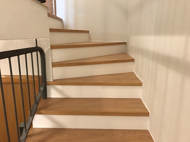 Escaleras forradas con huella de roble y contrahuella lacada blanca